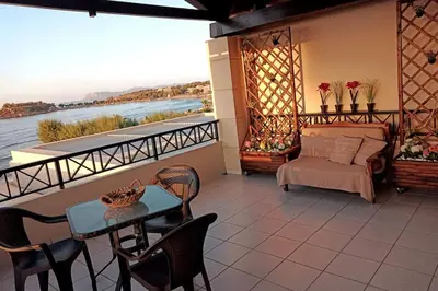 a balcony with a bed and a table and chairs at 'Sky and Sea 1' Apartment in Kato Daratso