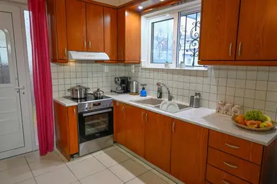a kitchen with wooden cabinets and a sink at Popi's House in Chania Town