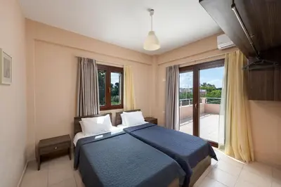 a bedroom with a blue bed and a balcony at Villa Stratianna by PosarelliVillas in Módhion