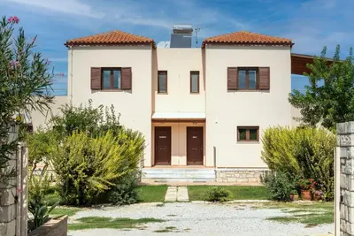 a large white house with brown shutters at Villa Stratianna by PosarelliVillas in Módhion