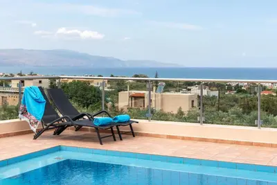 a view of a swimming pool and the ocean at Villa Stratianna by PosarelliVillas in Módhion