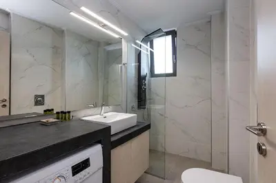a bathroom with a sink and a glass shower at Aurora apartments in Chania Town