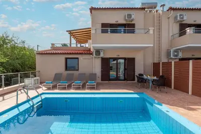 a villa with a swimming pool and a house at Villa Flora by PosarelliVillas in Módhion