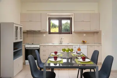 a kitchen with a table and chairs in a kitchen at Villa Flora by PosarelliVillas in Módhion
