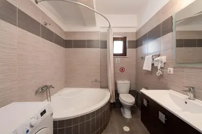 a bathroom with a tub and a toilet and a sink at Villa Flora by PosarelliVillas in Módhion
