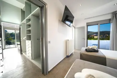 a bedroom with a bed and a sliding glass door at La Maison Du Soleil Luxury Villa by 8essentially in Varípetron