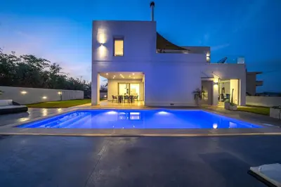 a swimming pool in front of a house at La Maison Du Soleil Luxury Villa by 8essentially in Varípetron