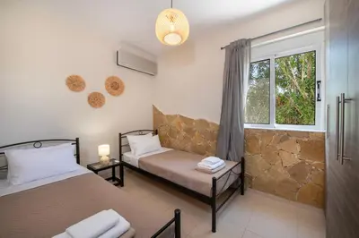 a bedroom with two beds and a window at Gabriel apartment with a shared pool close to the beach in Chorafakia