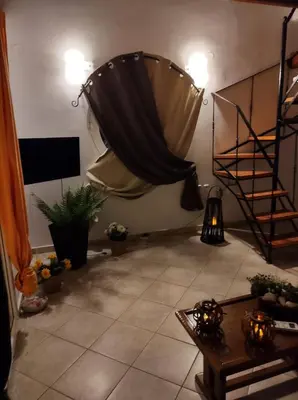 a living room with a curtain and a table and a staircase at Sky & Sea 2 in Kato Daratso