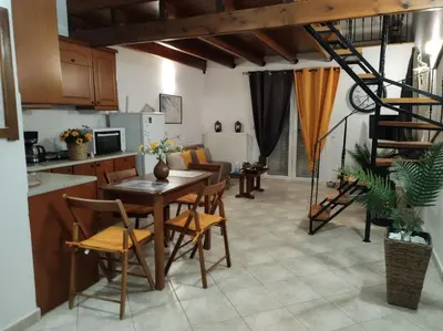 a kitchen and living room with a table and chairs at Sky & Sea 2 in Kato Daratso