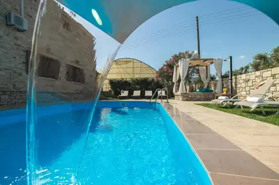 a pool with a water slide in a backyard at Villa Drapanias Homeleader in Drapaniás