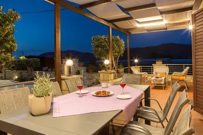 a table with two glasses of wine on a patio at Villa Drapanias Homeleader in Drapaniás