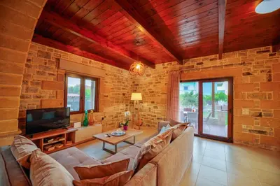 a living room with a couch and a tv at Villa Drapanias Homeleader in Drapaniás