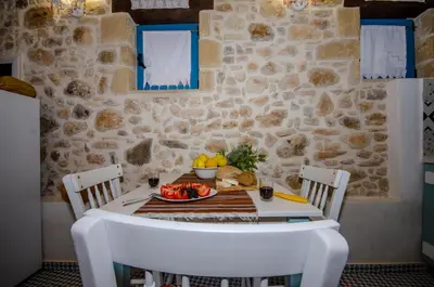 a table with a plate of fruit on it at Trigono Traditional House in Kalivianí
