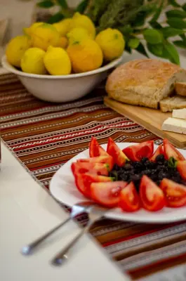 a plate of food with tomatoes and bread on a table at Trigono Traditional House in Kalivianí