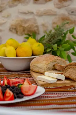 a table with a plate of bread and a bowl of fruit at Trigono Traditional House in Kalivianí