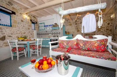 a living room with a couch and a bowl of fruit on a table at Trigono Traditional House in Kalivianí