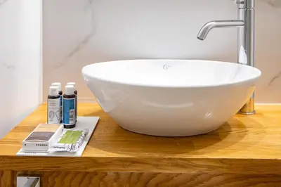 a white bowl sink on a wooden counter in a bathroom at Vener Suites in Chania Town