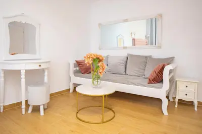 a living room with a couch and a vase of flowers on a table at Vener Suites in Chania Town