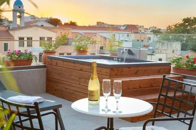 a bottle of wine on a table with two glasses at Vener Suites in Chania Town