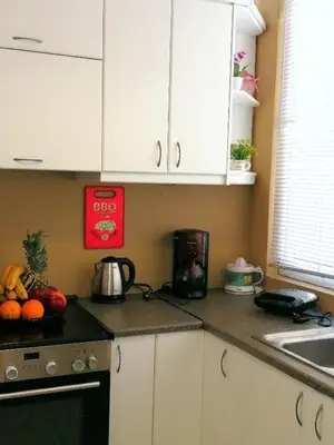 a kitchen with white cabinets and a counter top with fruit at Odyseia Apts ΙI at the Center of the City & Old Town in Chania Town