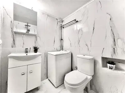 a white bathroom with a toilet and a sink at Odyseia Apts ΙI at the Center of the City & Old Town in Chania Town