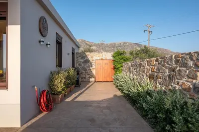 a building with a wooden door and a stone wall at Sia Elafonisi Pool House in Elafonisi