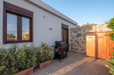 a home with a stone wall and a window and a door at Sia Elafonisi Pool House in Elafonisi