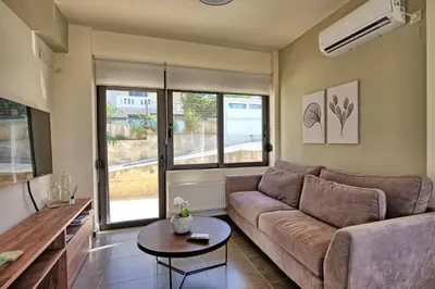 a living room with a couch and a table at Phaedra by PosarelliVillas in Kounoupidhianá