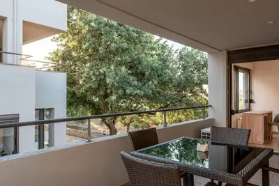 a view from the balcony of a house with a table and chairs at Phaedra by PosarelliVillas in Kounoupidhianá