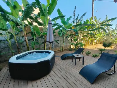 a hot tub on a deck with chairs and an umbrella at m&m's city loft in Chania Town