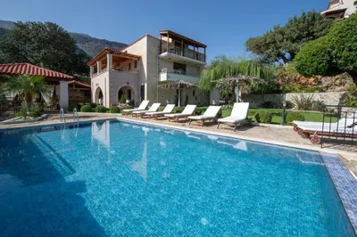 a swimming pool with chairs and a house at Geroulios Kastro Villas I 