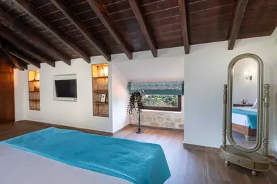 a bedroom with a blue bed and a mirror at Geroulios Kastro Villas I 