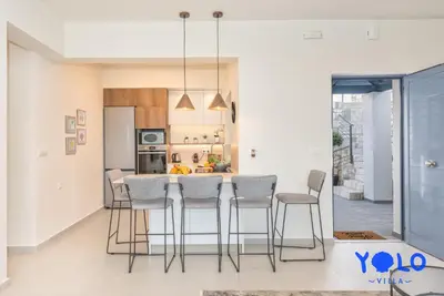 a kitchen with a table and chairs in a room at Villa YOLO in Almirida