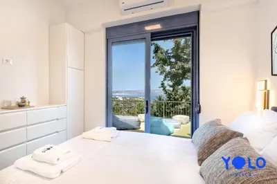a bedroom with a bed with a view of the ocean at Villa YOLO in Almirida