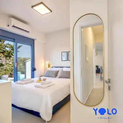 a bedroom with a large mirror and a bed at Villa YOLO in Almirida