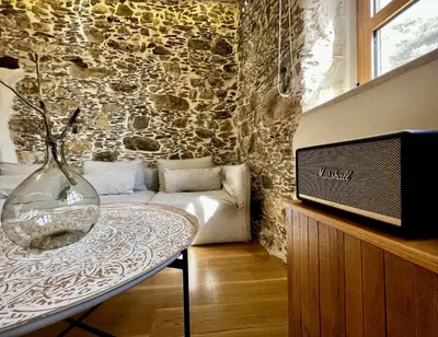 a living room with a table with a vase on it at The Stone House in Avdhoulianá