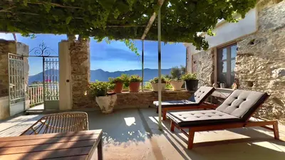 two chairs and a couch on a patio with a view at The Stone House in Avdhoulianá