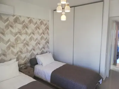 a bedroom with two beds and a wall at W Apartment in Chania Town