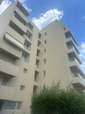 a white apartment building with a tree in front of it at W Apartment in Chania Town