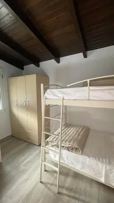 a bedroom with two bunk beds and a wooden ceiling at Gesthimani's Residence in Áyios Yeóryios