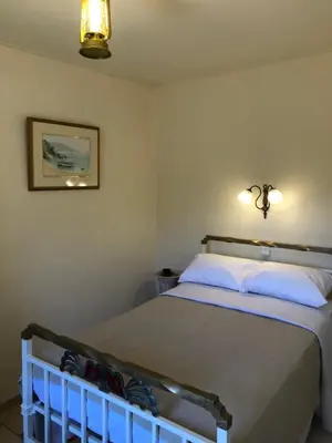 a bedroom with a bed with white pillows at ARETI Sea View Mountain Cottage in AmigdhalokeFálion