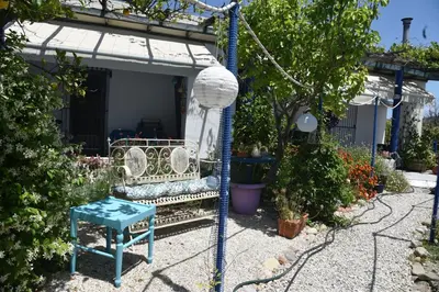 a swing in a garden with a bench and a table at Relaxing and Comfortable Studio Near Falasarna Beaches in Plátanos