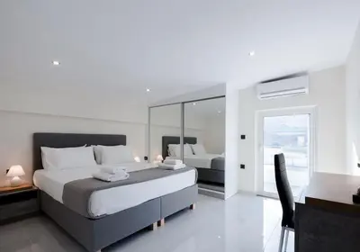 a bedroom with a large bed and a mirror at Home Sweet Home - Big Balcony with Great View in Kissamos