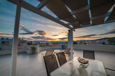 a table and chairs on a balcony with a sunset at Home Sweet Home - Big Balcony with Great View in Kissamos