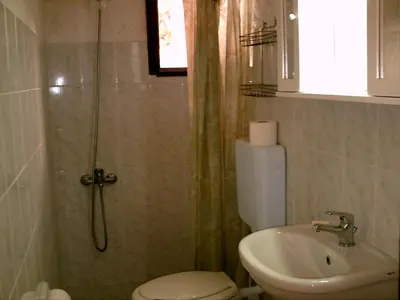 a bathroom with a shower and a toilet and a sink at Summer Lodge in Maleme