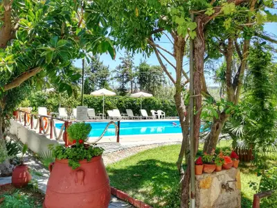 a resort with a swimming pool and trees and plants at Summer Lodge in Maleme