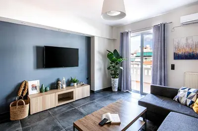 a living room with a flat screen tv on a wall at Nostos Central Apartment in Chania Town