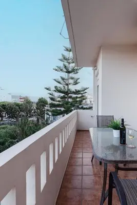 a balcony with a table and a pine tree at Nostos Central Apartment in Chania Town