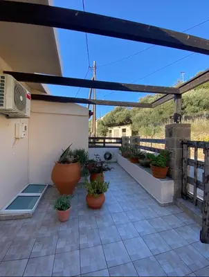 a patio with potted plants on a roof at Koundouros Home in AmigdhalokeFálion